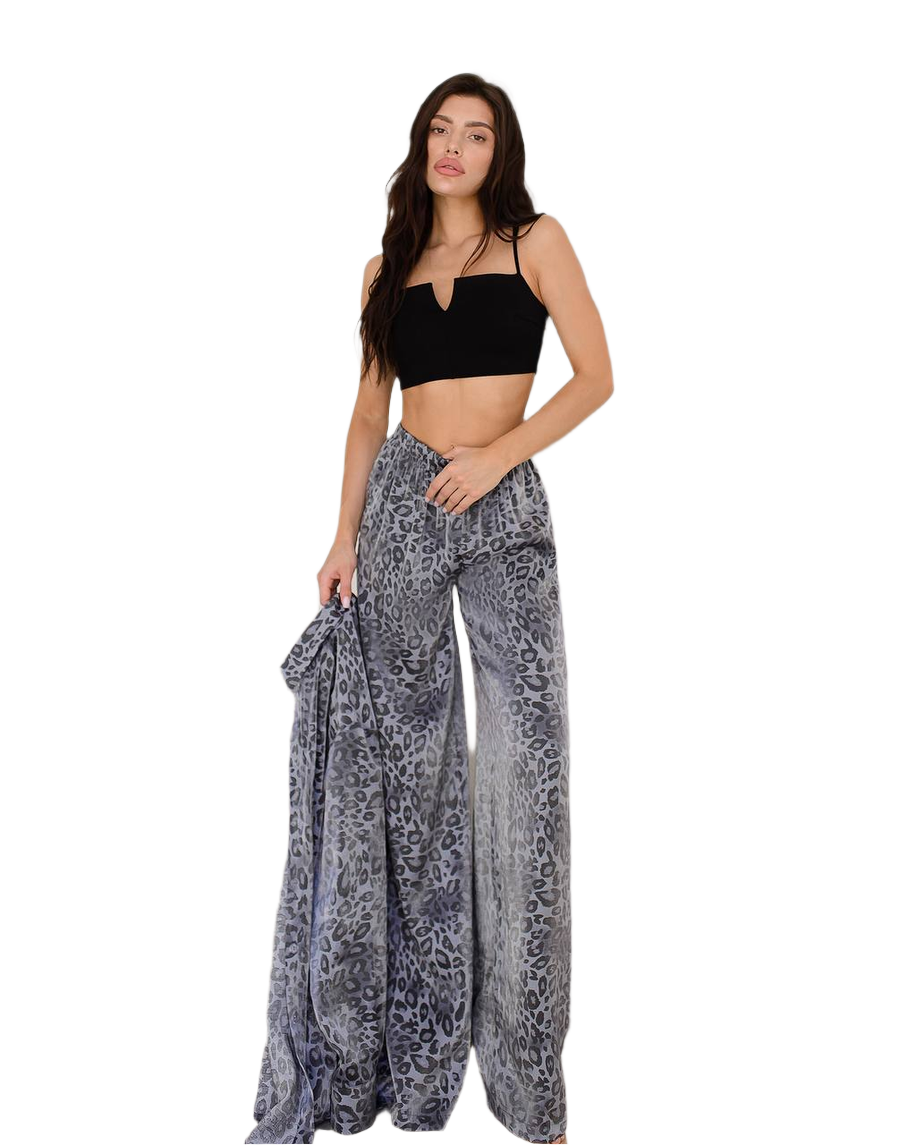 Woman wearing a black top and patterned pants on a white background