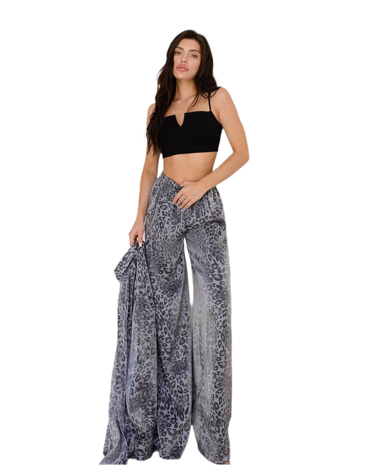 Woman wearing a black top and patterned pants on a white background