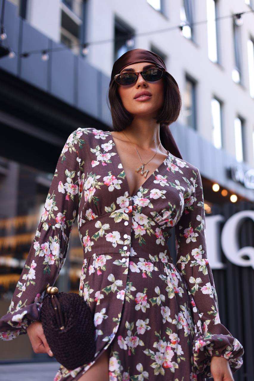 Woman wearing a floral dress with a blurred city street background
