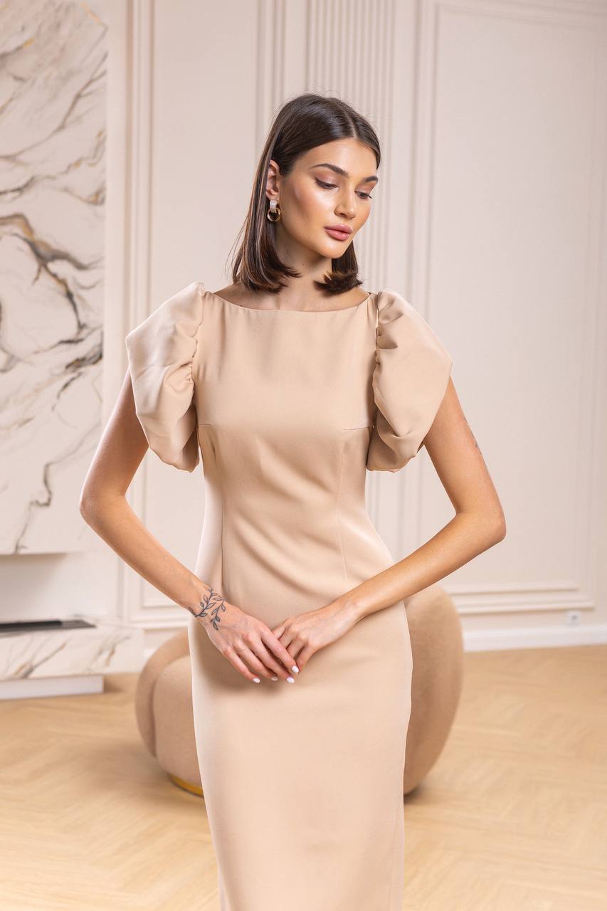 Woman wearing a beige dress in an elegant indoor setting