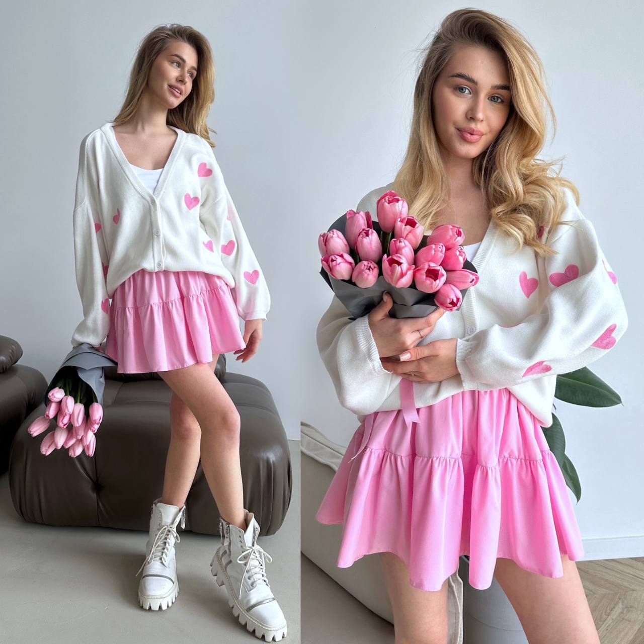 Woman in a white sweater with pink heart patterns and a pink skirt holding pink tulips.