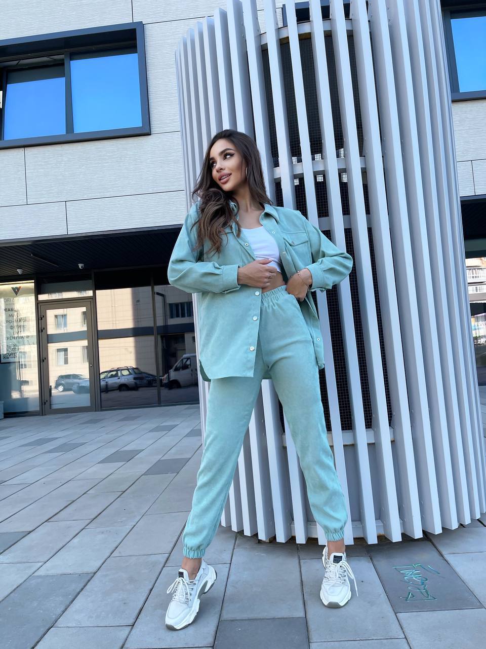 Woman in a mint green outfit standing in an urban setting