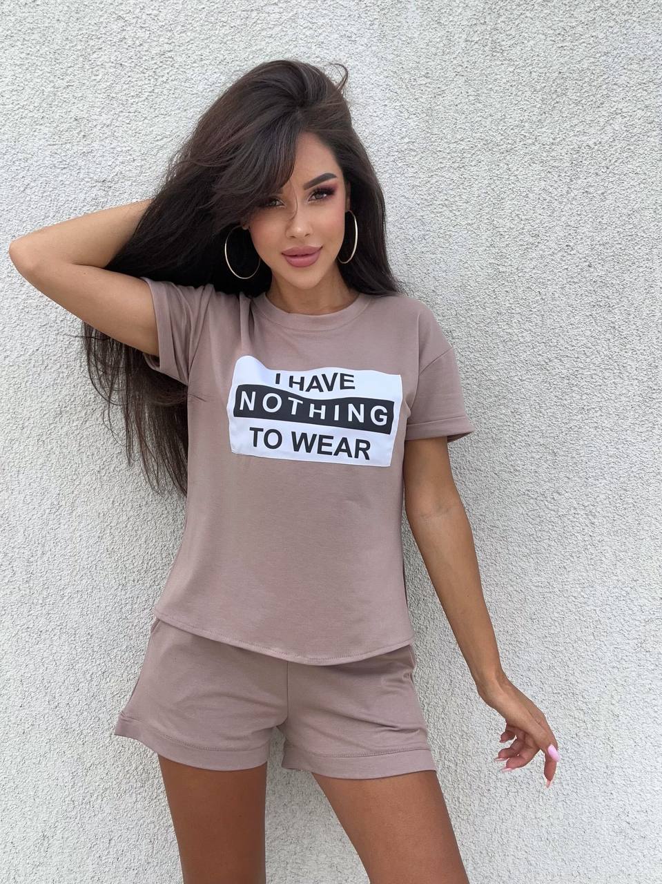 Woman wearing a brown t-shirt with a humorous print against a plain background