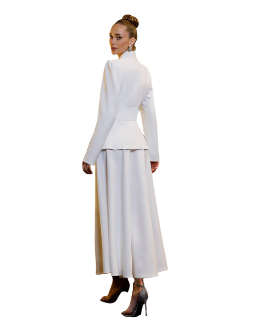 Woman wearing a white outfit with a high collar and long skirt on a white background