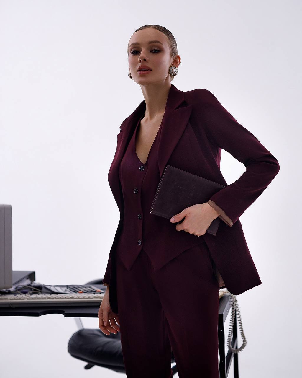 Woman in a burgundy suit standing in an office setting