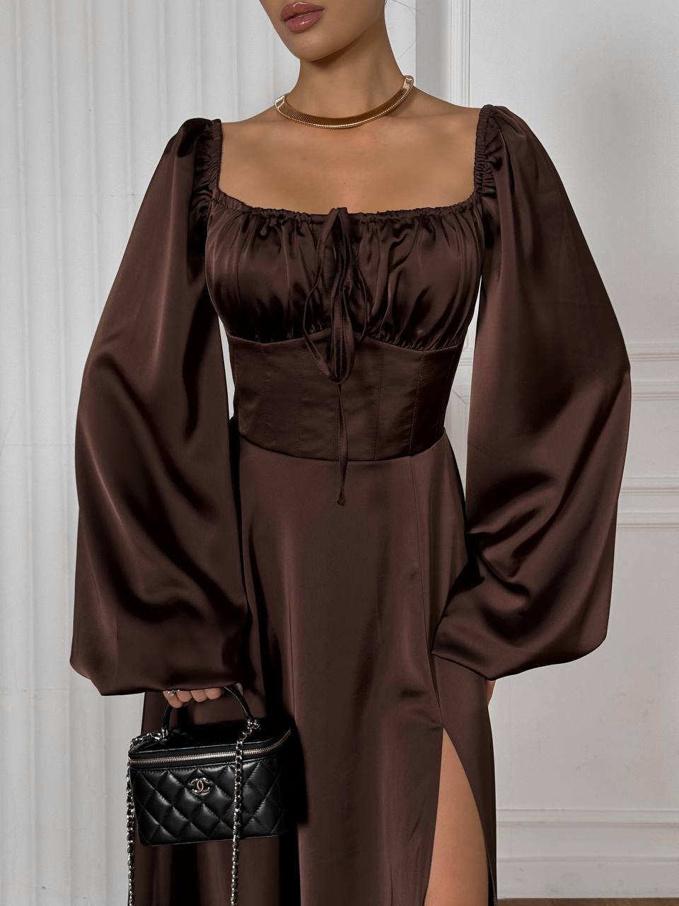 Brown satin outfit with wide sleeves against a neutral background