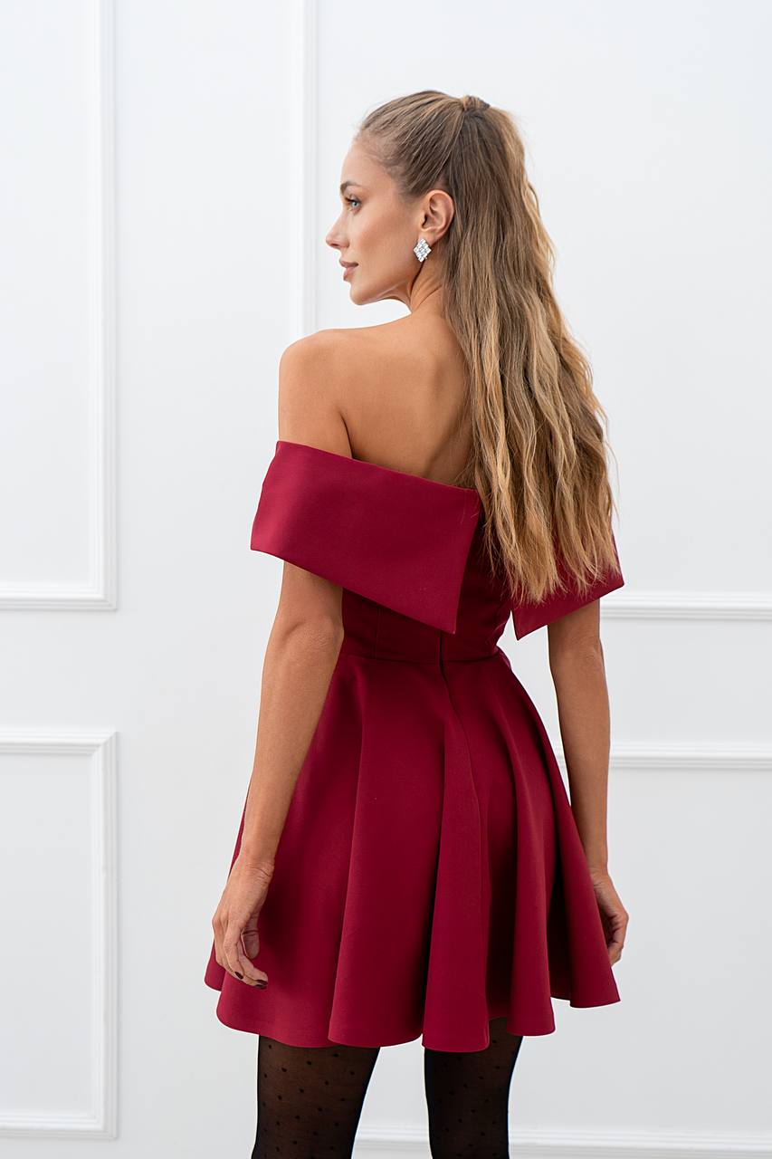 Woman wearing a red off-shoulder dress against a white background