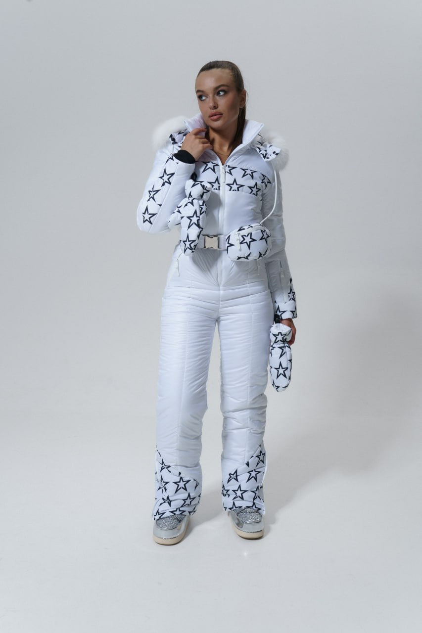 Person wearing a white snowsuit with star patterns on a plain background