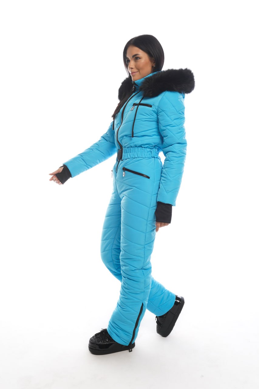 Person wearing a blue snowsuit with black accents on a white background