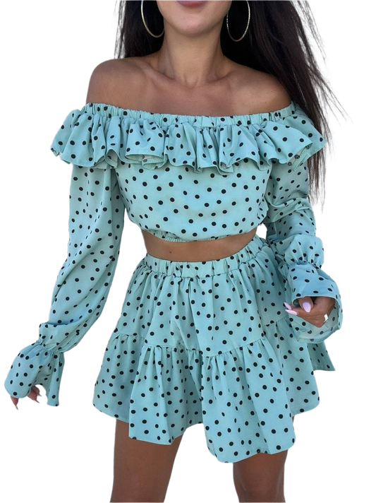 Woman wearing a light blue polka dot off-shoulder top and skirt set on a white background
