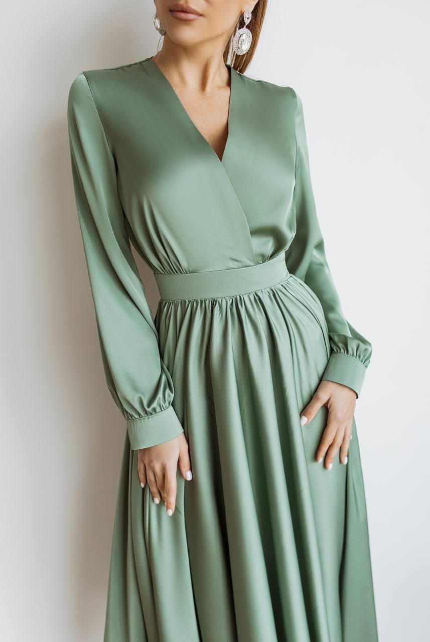 Green dress with long sleeves on a plain background