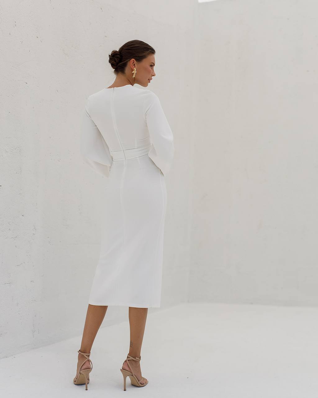 Woman wearing a white dress against a plain background