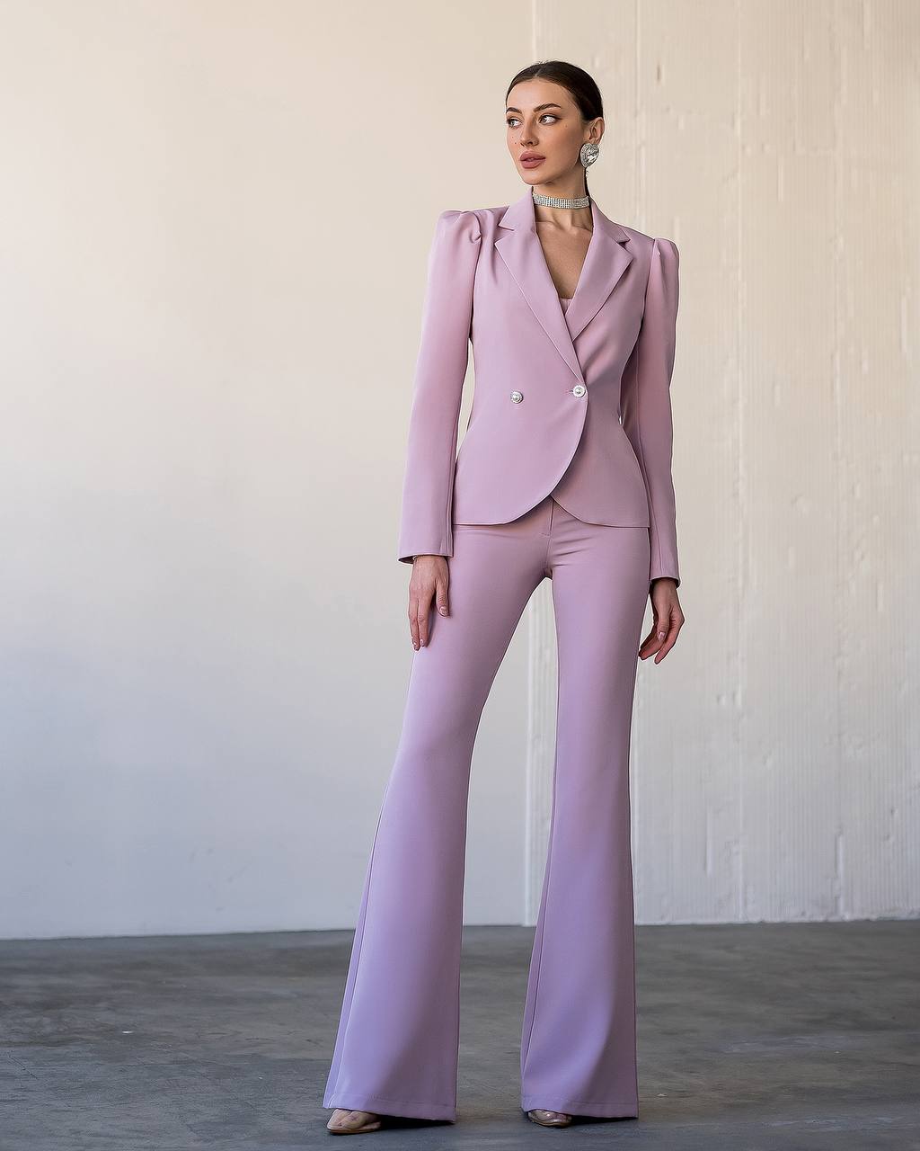 Woman wearing a lavender suit against a plain background