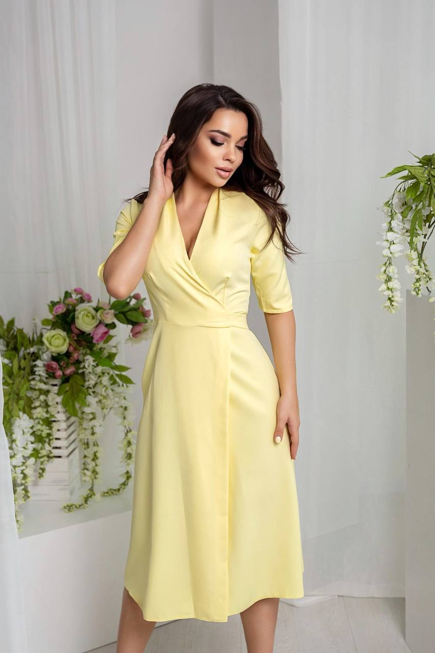 Woman wearing a yellow dress with floral decorations in the background