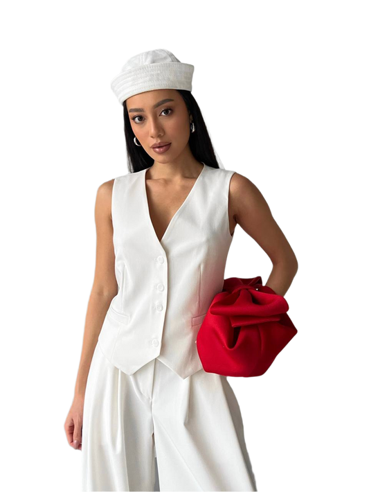 Woman in a white outfit with a red clutch on a white background