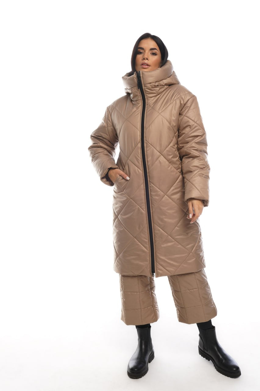 Woman wearing a beige quilted coat on a white background