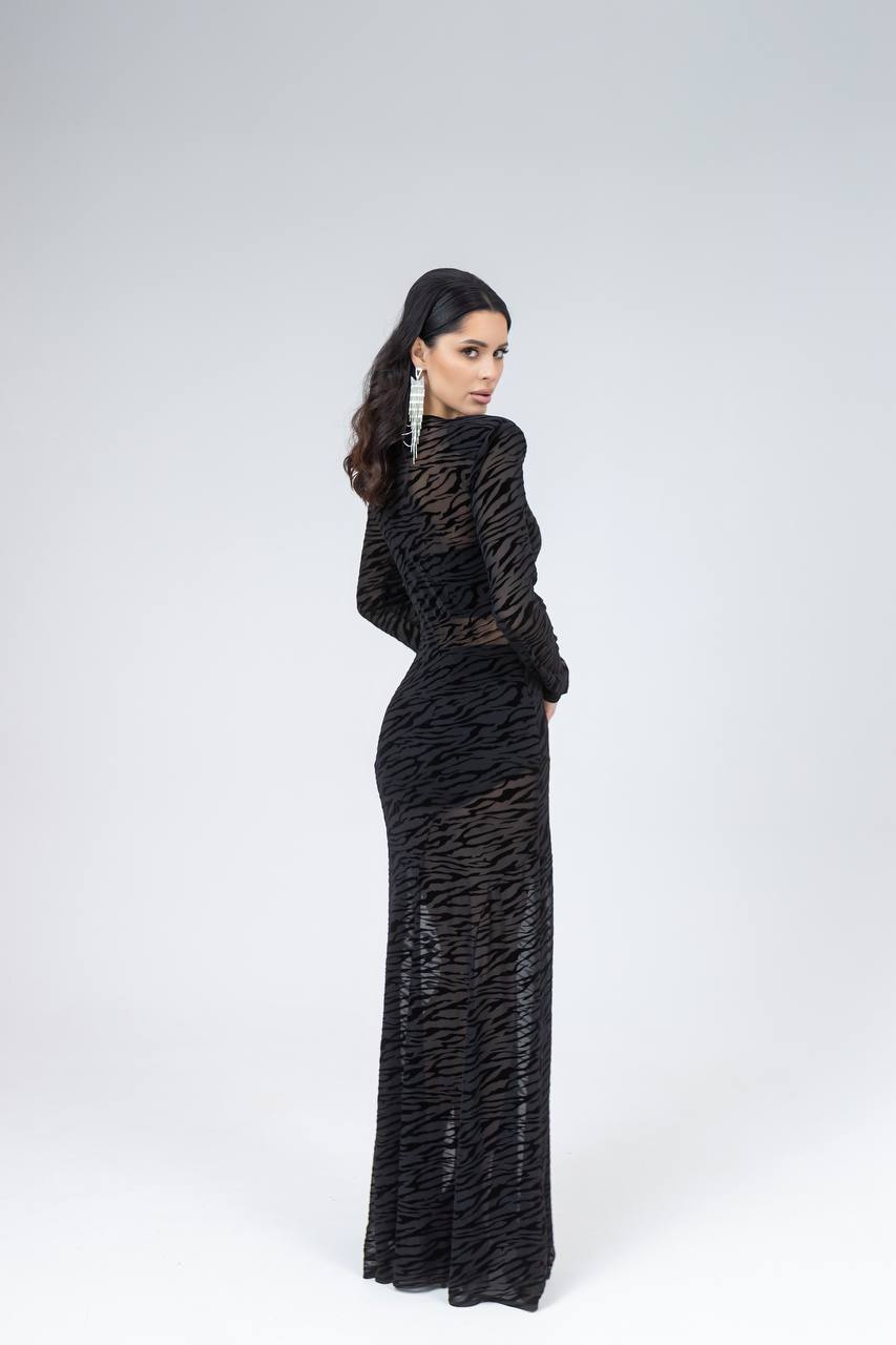 Woman wearing a black patterned dress on a white background