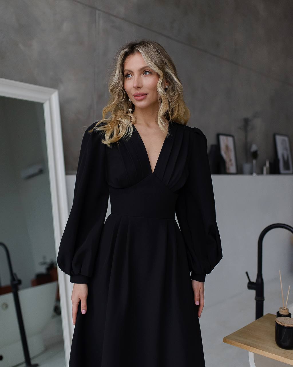 Woman wearing a black dress in an indoor setting