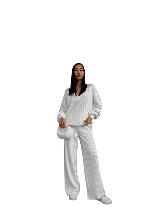 Woman wearing a white outfit with a matching handbag on a white background