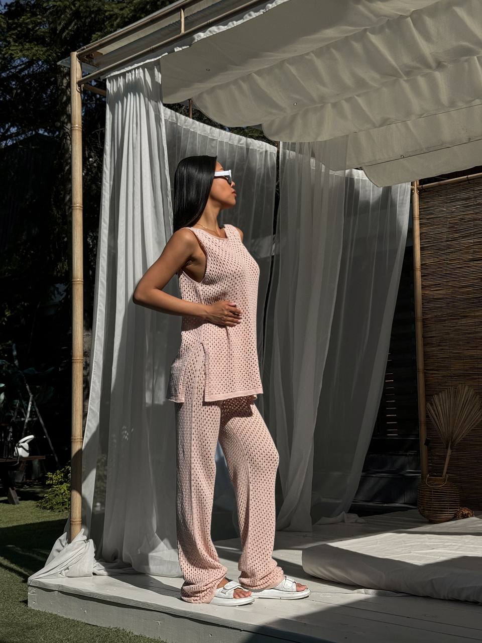 Woman in a pink outfit standing under a white canopy