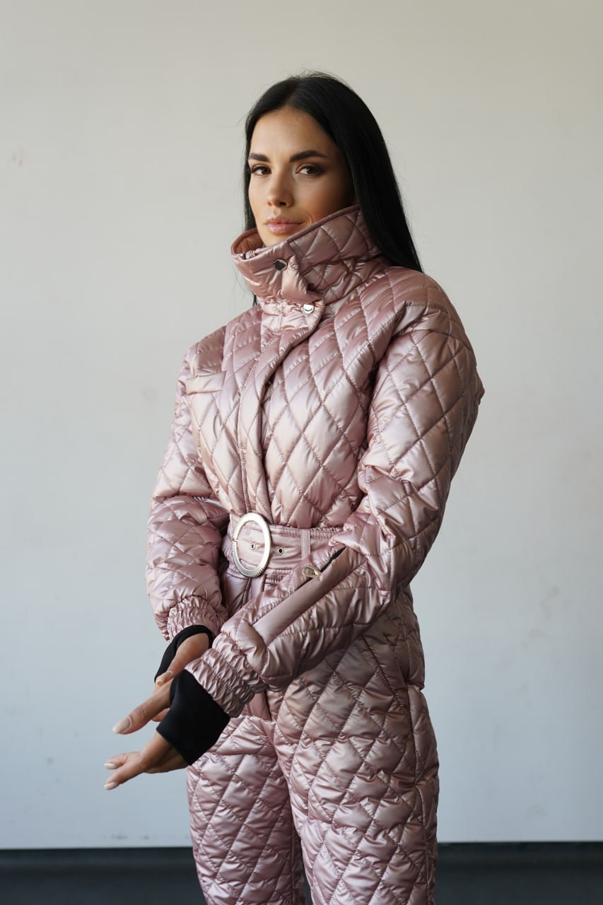 Woman wearing a pink quilted outfit against a plain background