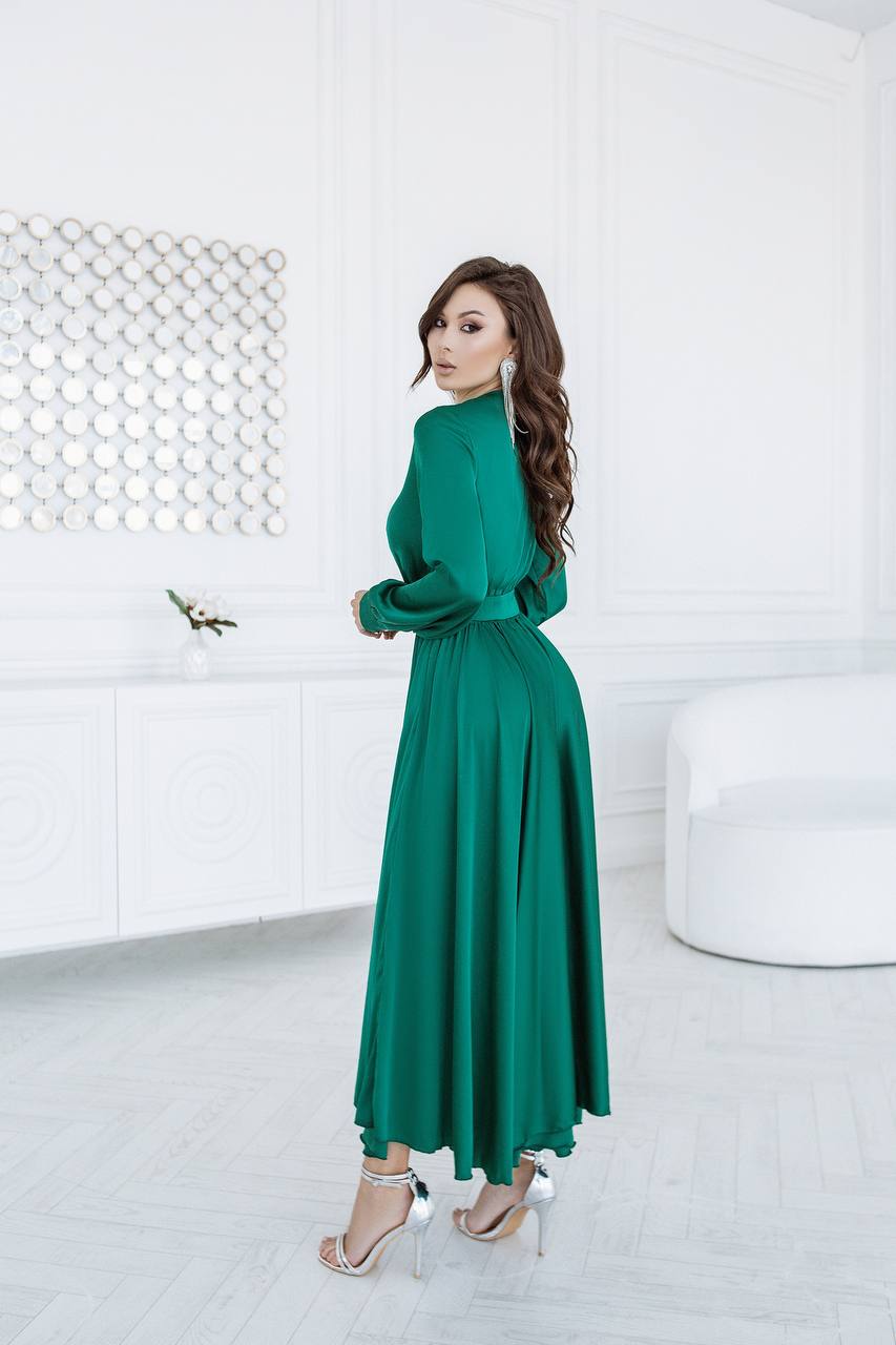 Woman in a green dress standing in a modern white room