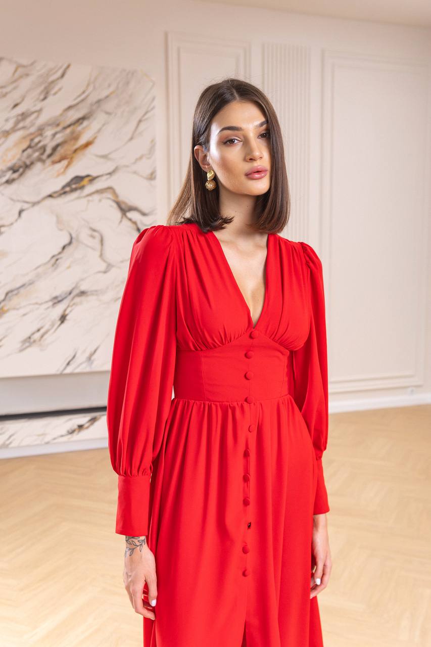 Woman wearing a red dress with a marble wall background
