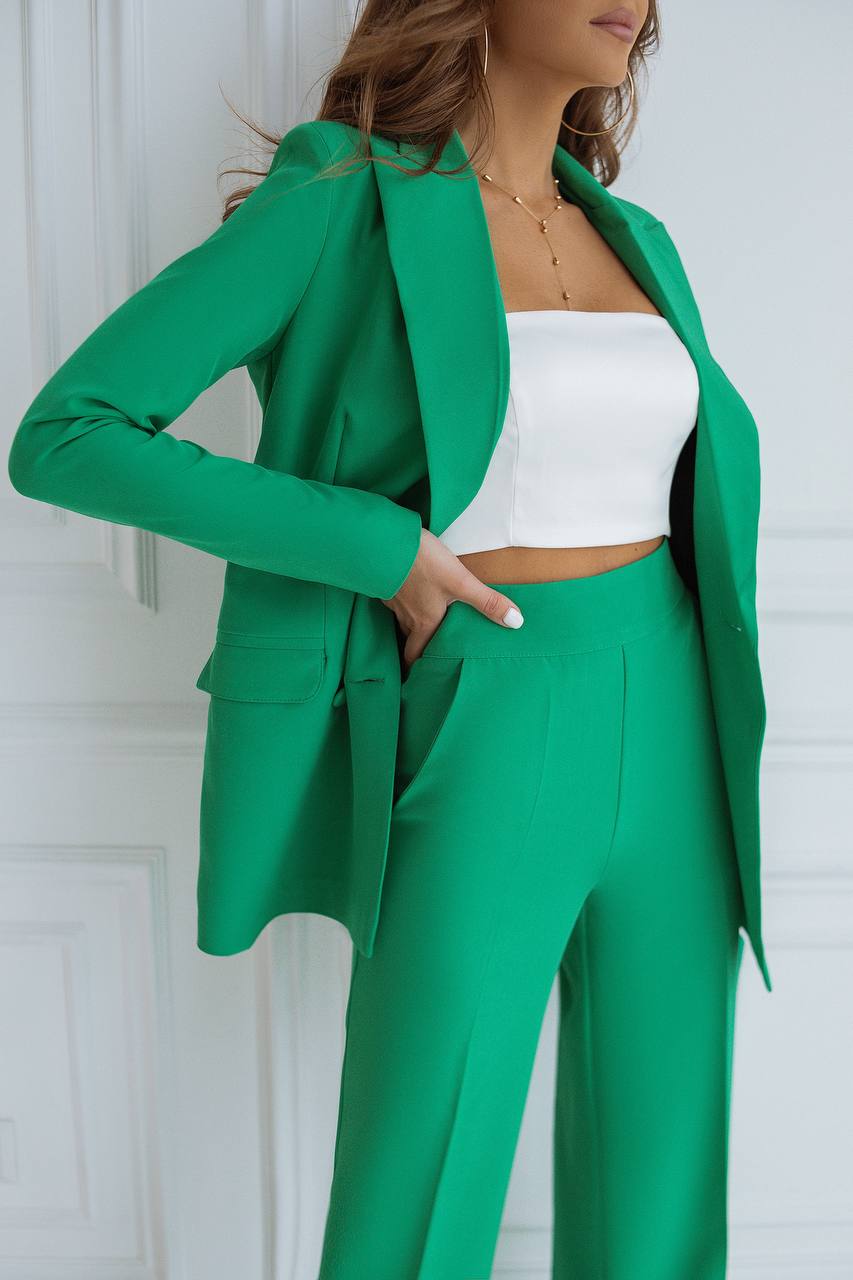 Person wearing a green suit with a white top against a white background