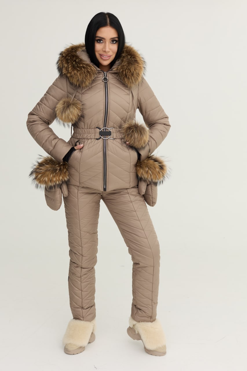 Woman wearing a beige winter suit with fur accents on a white background