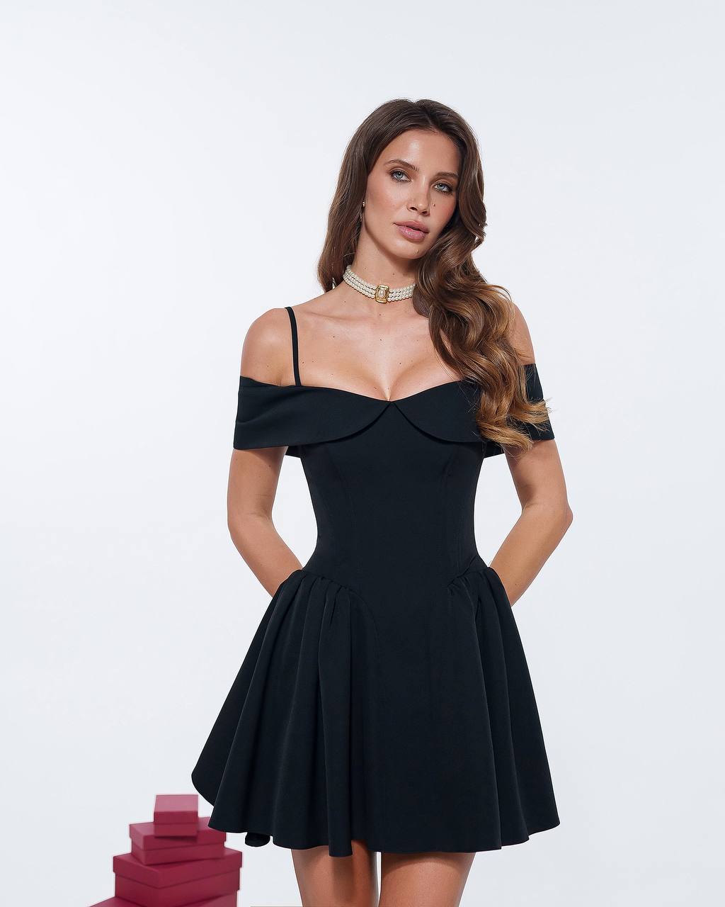 Woman wearing a black off-shoulder dress on a white background