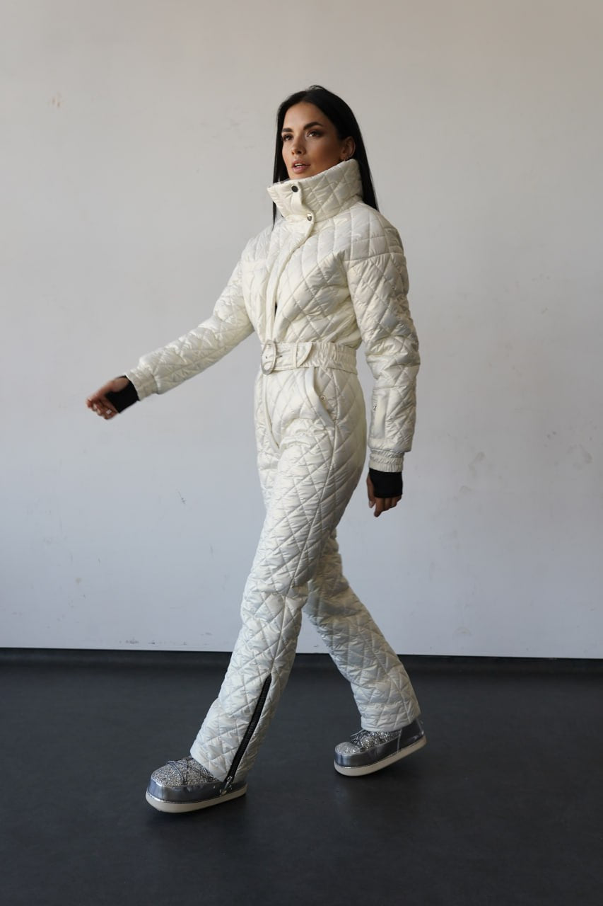 Person wearing a white quilted snowsuit against a plain background