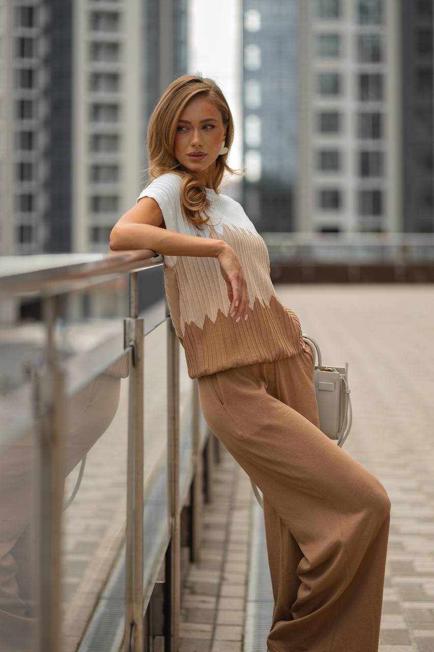 Woman in a stylish outfit standing on a rooftop with cityscape background