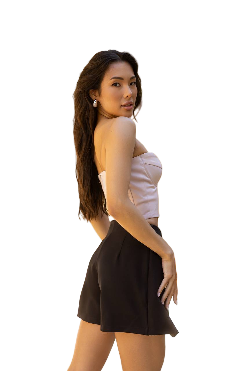 Woman wearing a white top and black shorts on a white background