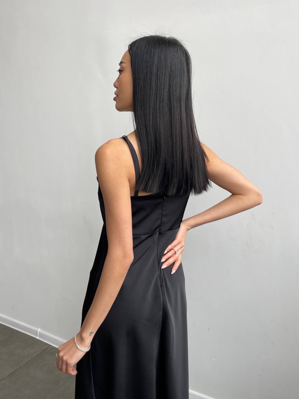 Woman wearing a black dress against a plain background