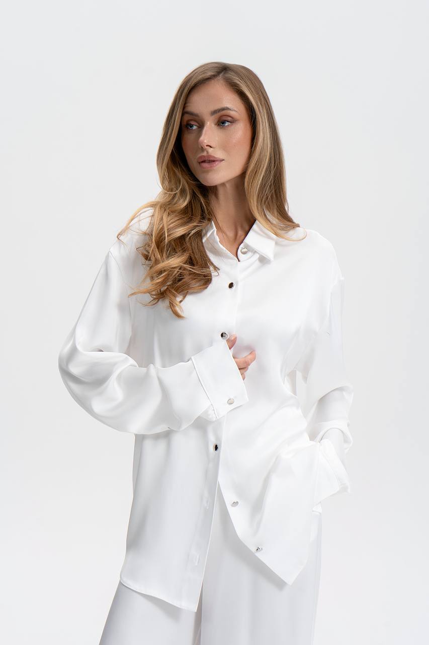 Woman wearing a white shirt against a plain background