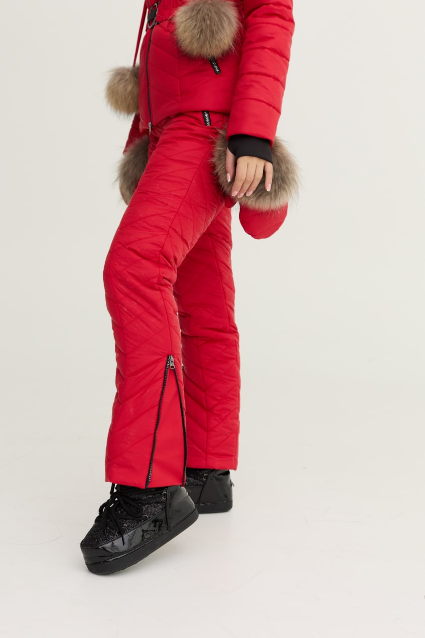 Person wearing a red winter suit with fur-lined hood on a white background
