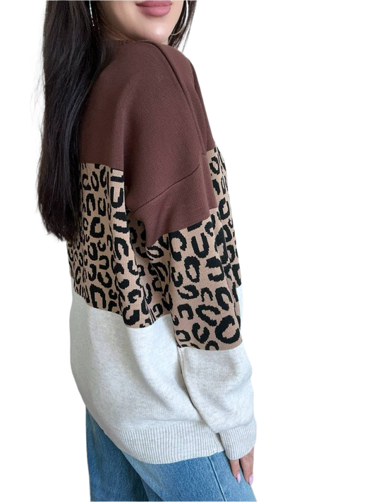 Person wearing a brown and beige sweater with leopard print pattern on a white background