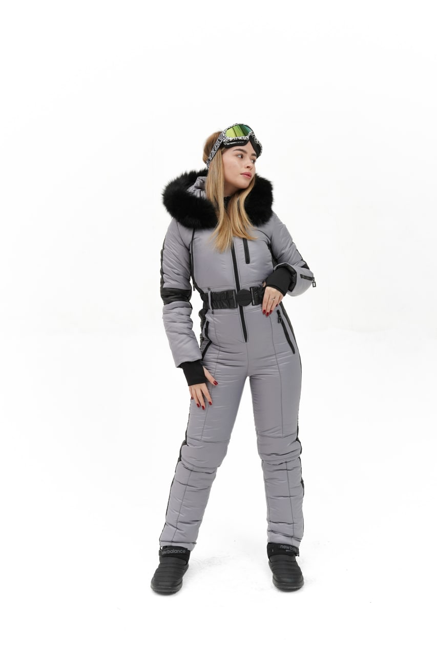 Person wearing a gray snowsuit with black accents on a white background