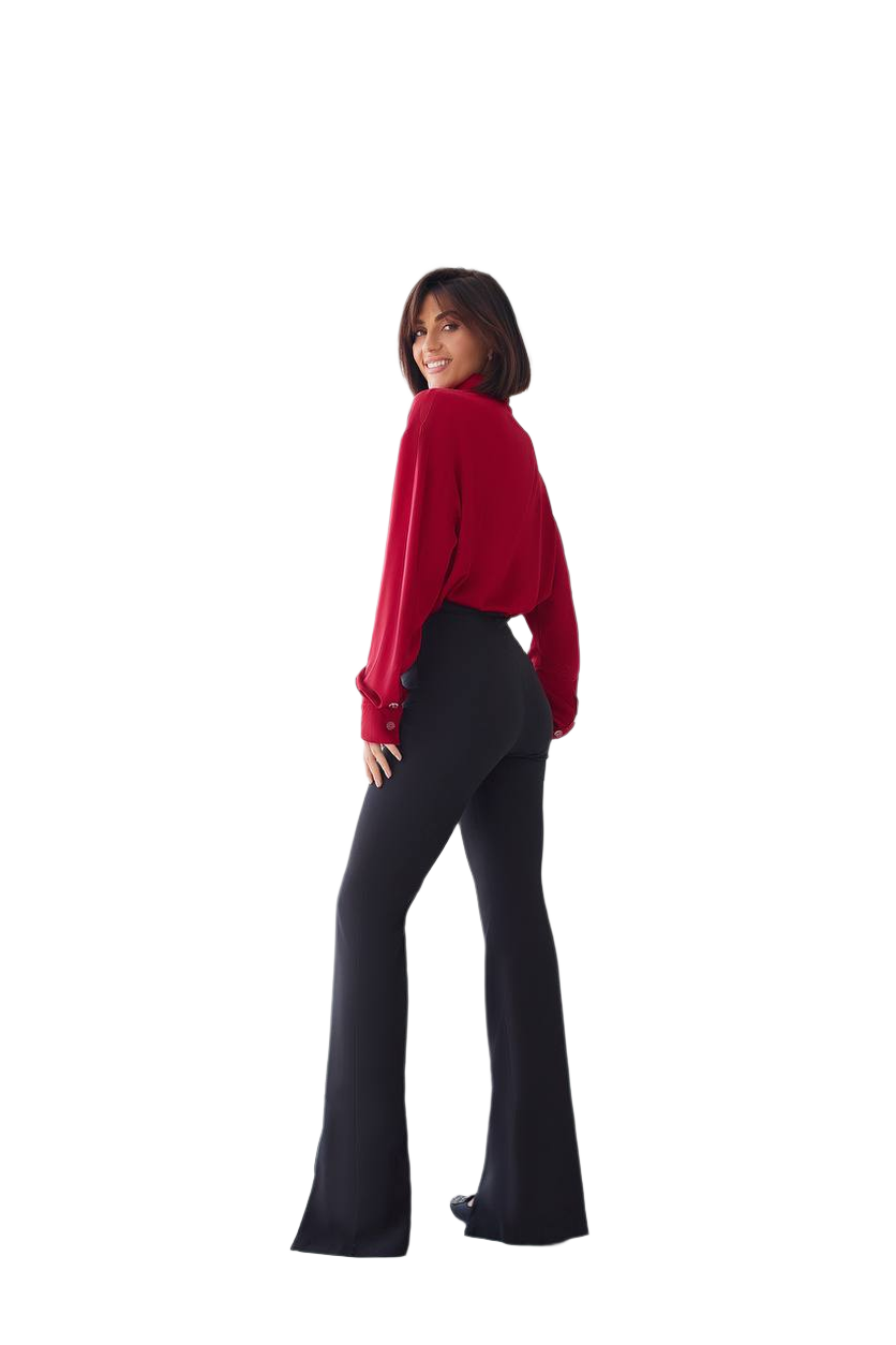 Person wearing a red top and black flared pants on a white background