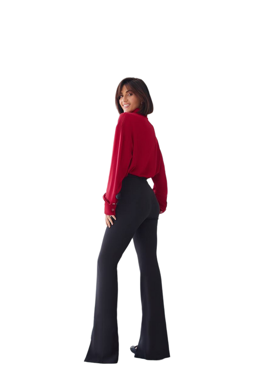 Person wearing a red top and black flared pants on a white background