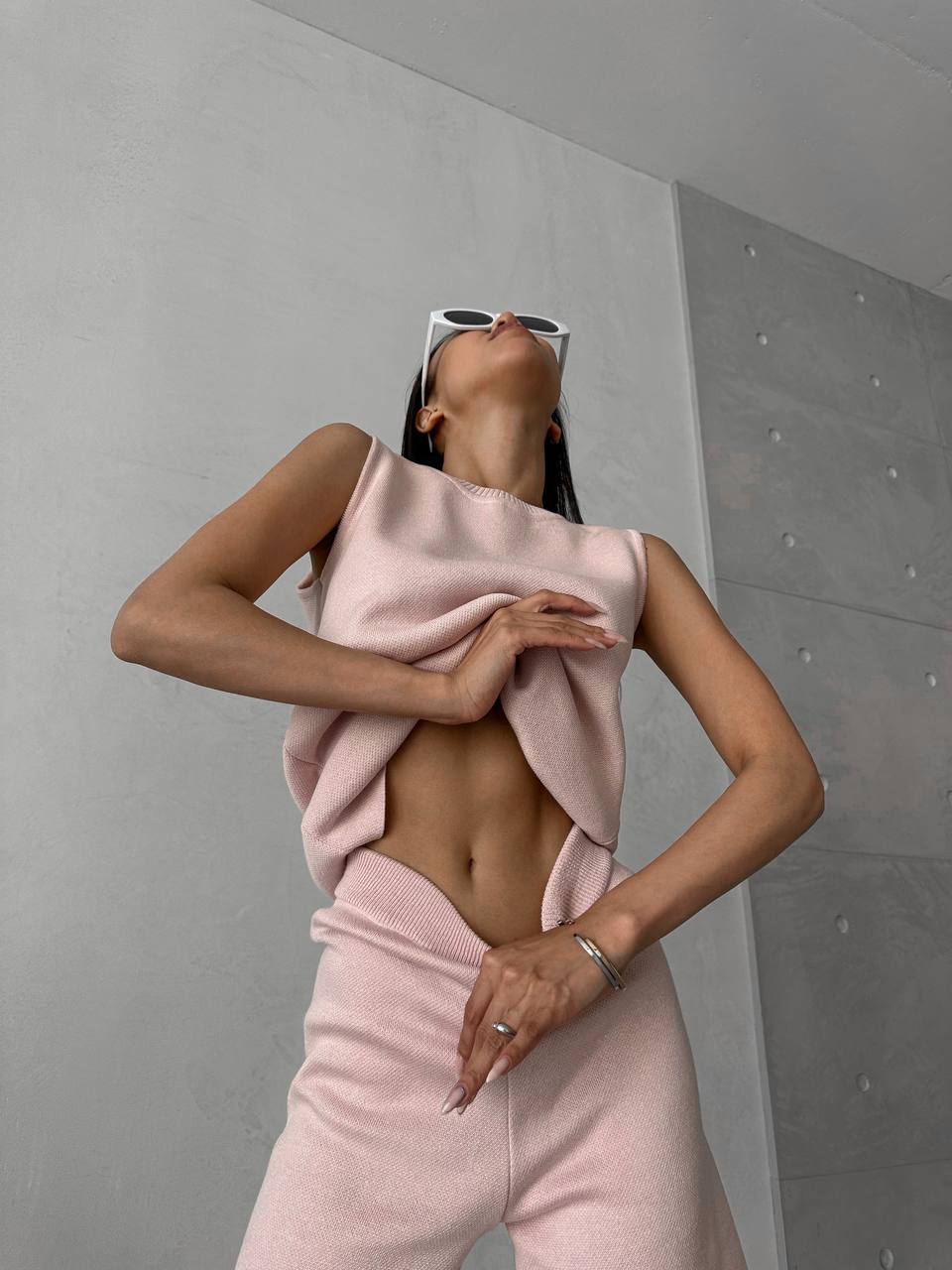 Person wearing a pink outfit against a gray wall