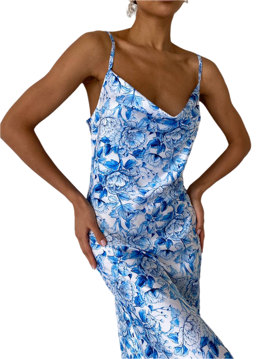 Woman wearing a blue floral slip dress on a white background