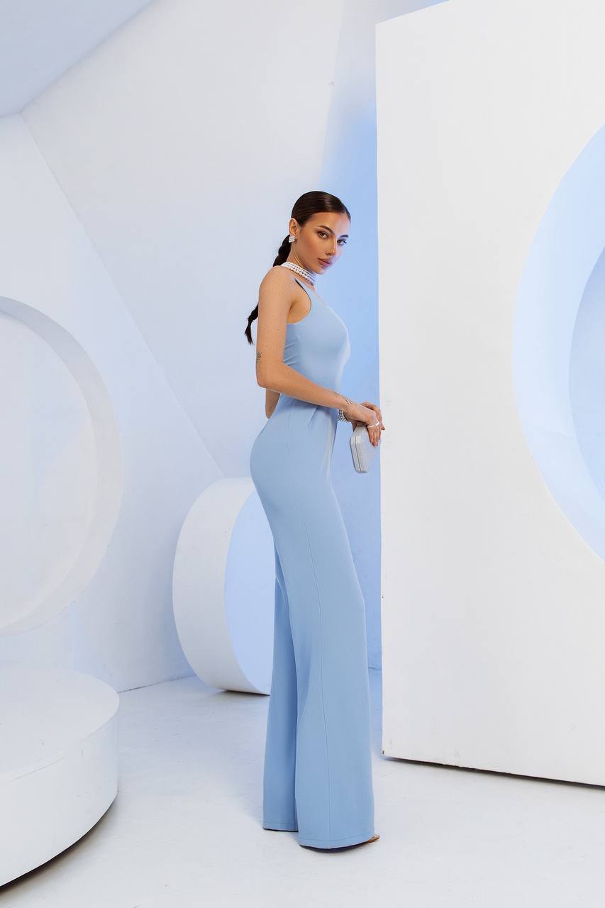 Woman in a light blue outfit standing in a futuristic, white interior setting.