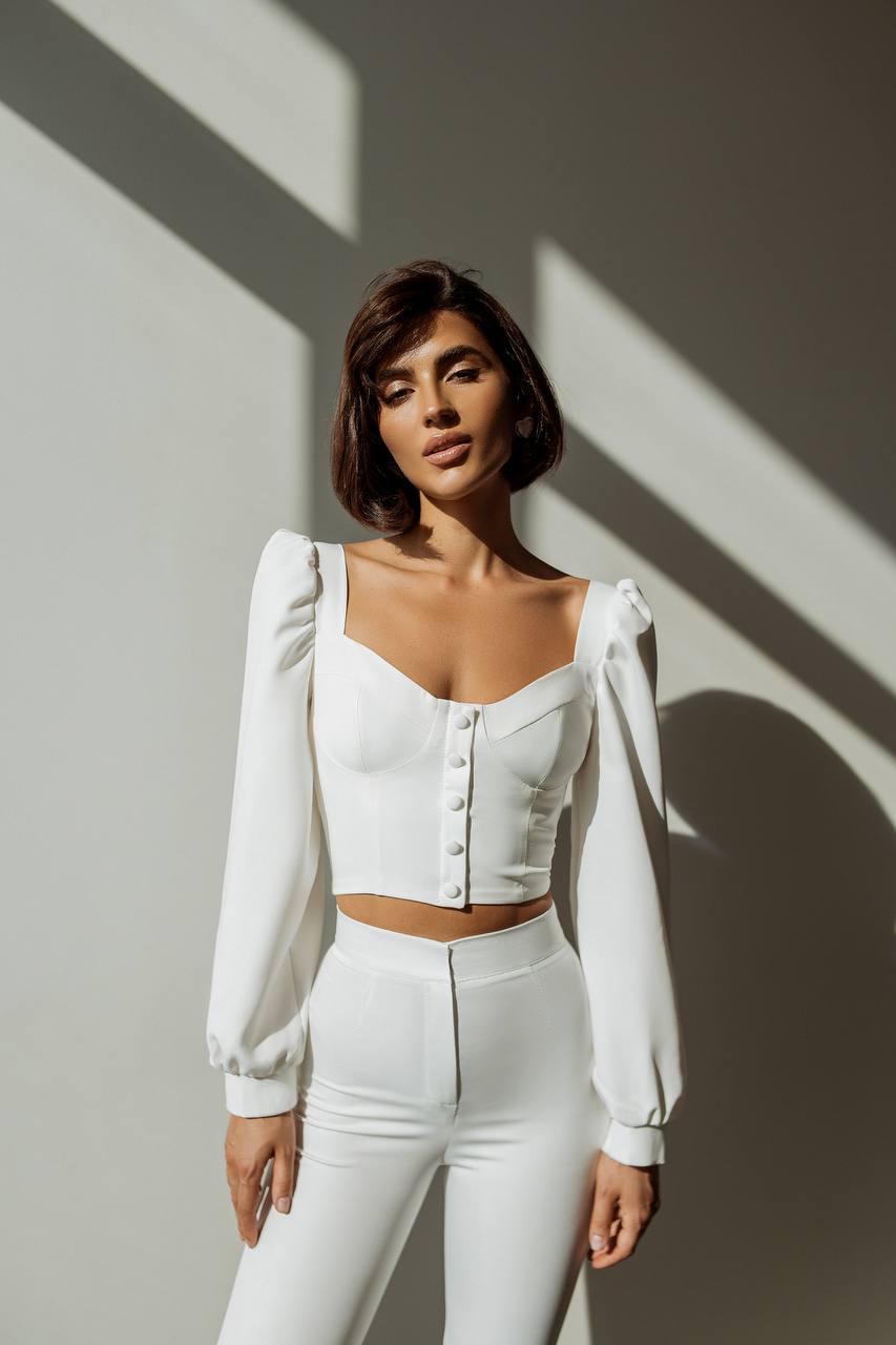 Woman wearing a white outfit with a plain background