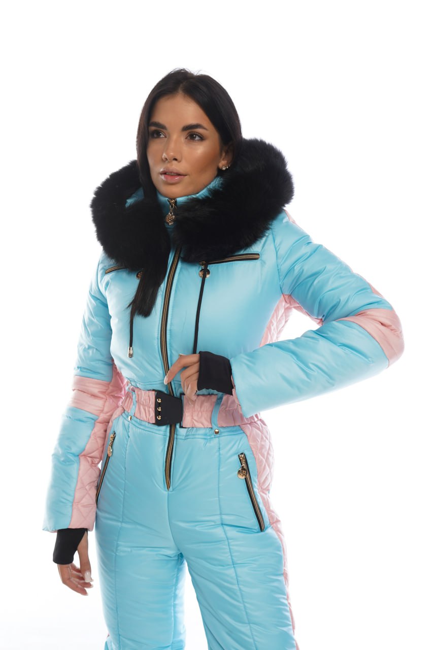 Woman wearing a light blue ski suit with black fur trim on a white background