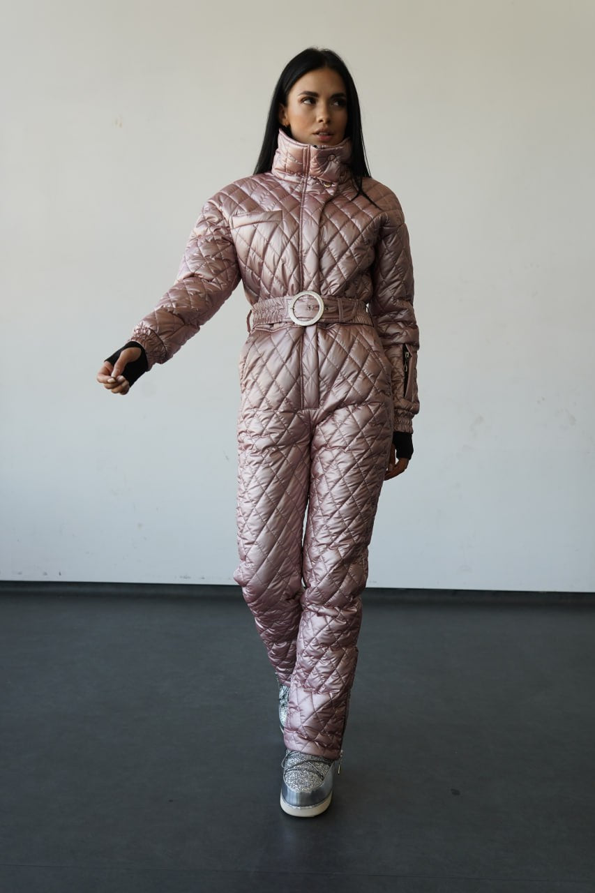 Person wearing a quilted pink snowsuit against a plain background