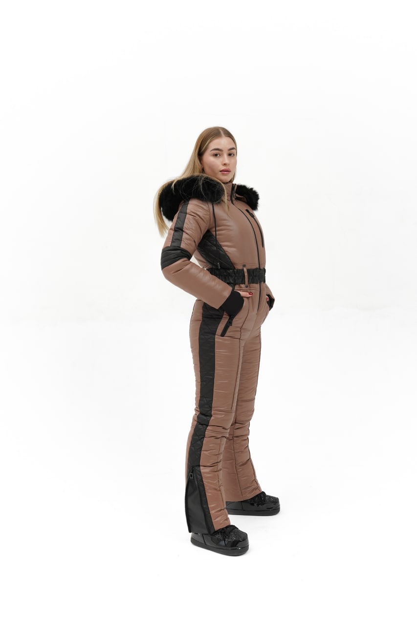 Person wearing a brown and black snowsuit with fur-lined hood on a white background