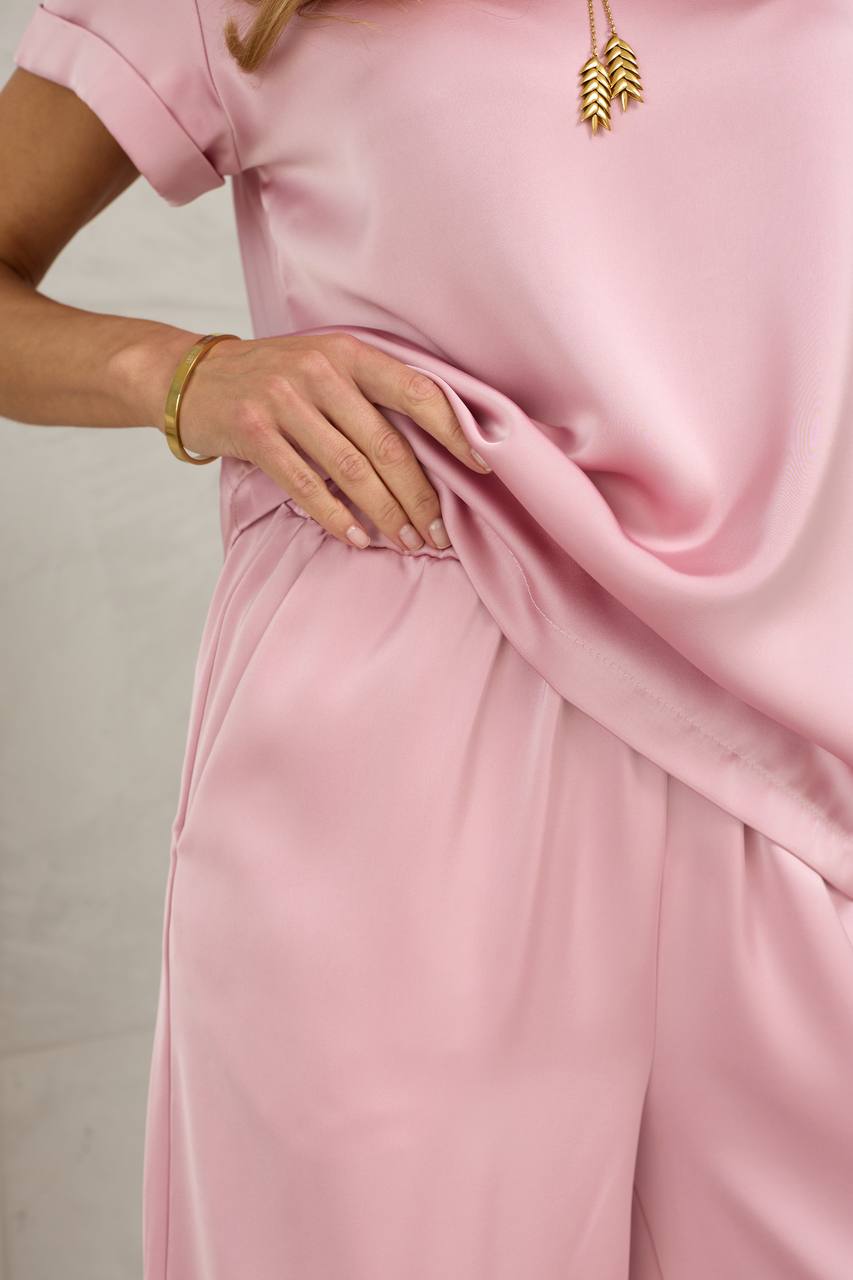 Person wearing a pink outfit with a plain background