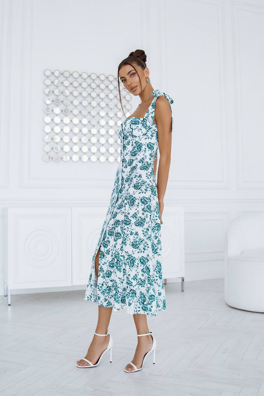 Woman wearing a floral dress in a minimal white room