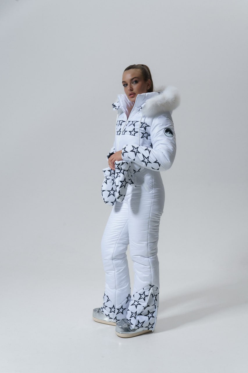 Person wearing a white puffer suit with star patterns on a plain background